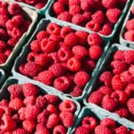 Boxes of organic raspberries on a farmers market stall.