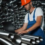 With equipment. Man in uniform works on the production. Industrial modern technology.