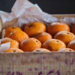 Close up view of juicy ripe oranges in wooden box with inscription
